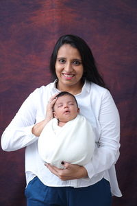 High angle view of cute baby girl sitting on bed at home