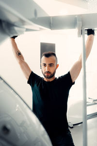 Portrait of young man standing against wall