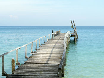 Wooden pier on sea against sky