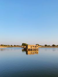 Scenic view of lake against clear blue sky