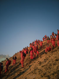 View of climate activists in red onzies at sunrise