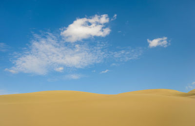 Scenic view of desert against blue sky