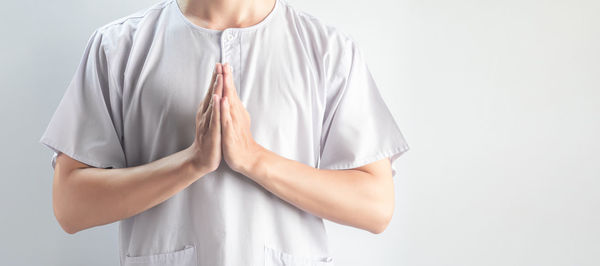 Midsection of woman standing against white background