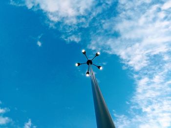 Low angle view of illuminated floodlight against blue sky