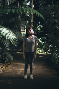 Full length of woman standing in forest