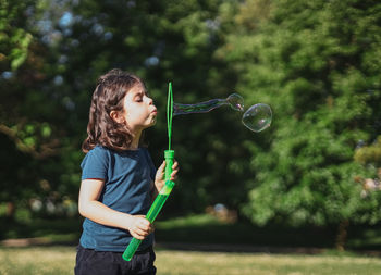 Portrait of young woman blowing bubbles