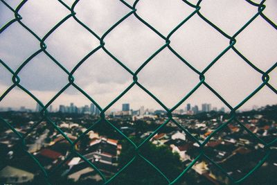 Cityscape seen through chainlink fence