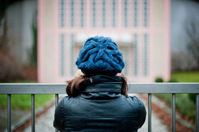 Rear view of woman standing against railing