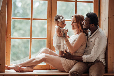 Young couple sitting on window