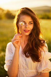 Portrait of young woman sitting on field