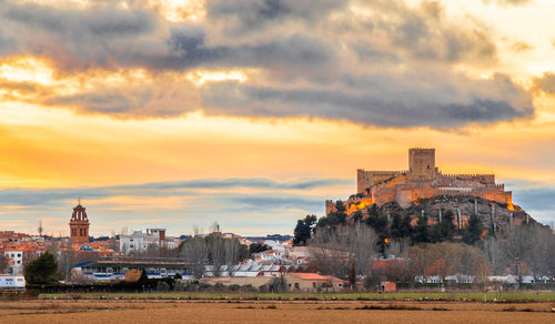 Buildings in city against sky during sunset