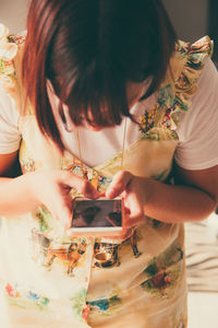 Close-up of woman using mobile phone while standing at home