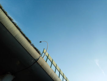 Low angle view of crane against clear blue sky