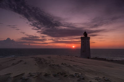 Lighthouse rubjerg knude at sunset on a stormy evening with dramatic sky