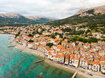 High angle view of townscape by sea against sky