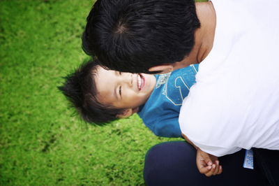 Close-up of father and carrying son at yard