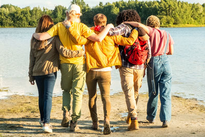 Rear view of friends walking at beach