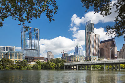 Low angle view of skyscrapers against cloudy sky