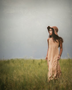 Woman wearing hat standing on field