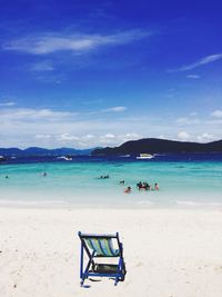 Deck chairs on beach against blue sky