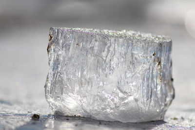 Frozen shiny ice cube melting in the sun with nice reflections in the transparent ice in arctic