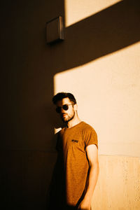 Young man standing against wall