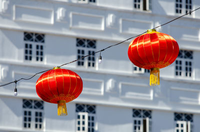 Low angle view of red lanterns hanging against building