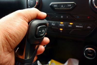 Cropped hand of man holding gearshift in car