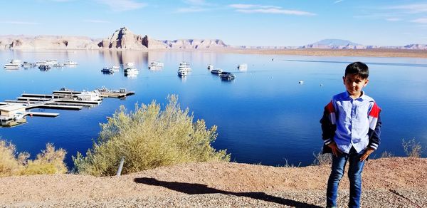 Full length of boy standing on beach against sky