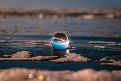 Close-up of crystal ball on beach