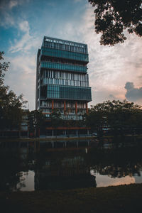 Reflection of building in river against sky