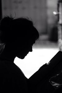 Close-up portrait of silhouette woman using mobile phone