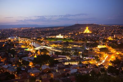 Illuminated townscape against sky during sunset