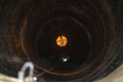 Close-up of illuminated lighting equipment dropping from well