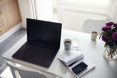 Laptop and diary on kitchen table