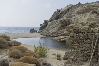 Rocks on beach against sky