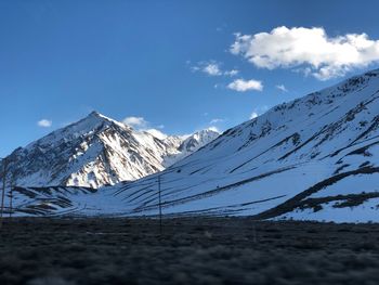 Scenic view of snowcapped mountains against blue sky