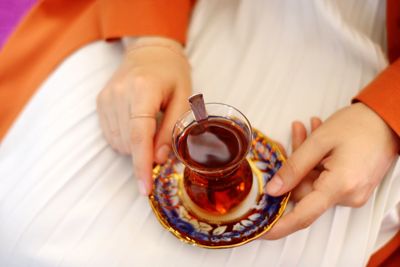 Midsection of woman having herbal tea at home