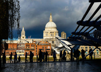 Group of people in front of buildings against sky in city