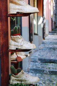 Low section of lants potted in shoes on street against building