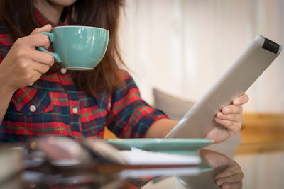 Midsection of woman holding coffee cup