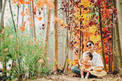 Group of people sitting on autumn leaves