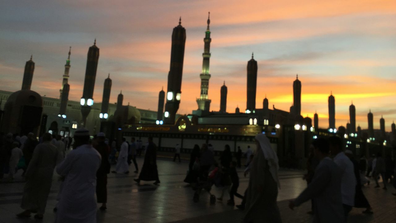 GROUP OF PEOPLE IN CITY AT SUNSET