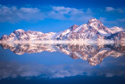 Scenic view of snowcapped mountains against blue sky