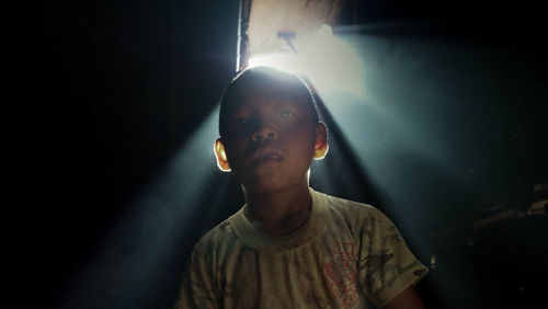 Low angle portrait of boy in darkroom