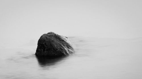 Rock formation in sea against sky