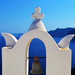 Bell tower by sea against sky at santorini