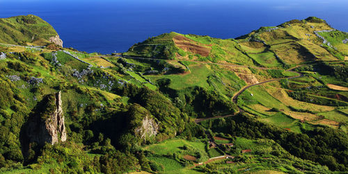 Scenic view of mountain by sea against clear sky