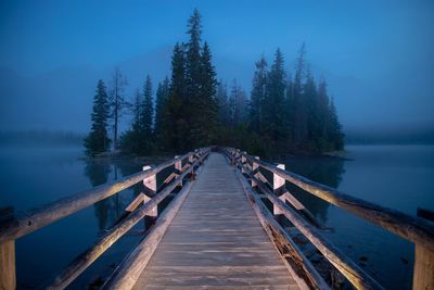Empty pier over lake at dusk