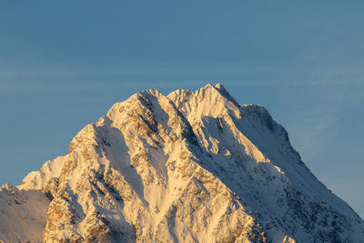 Low angle view of snowcapped mountains against sky